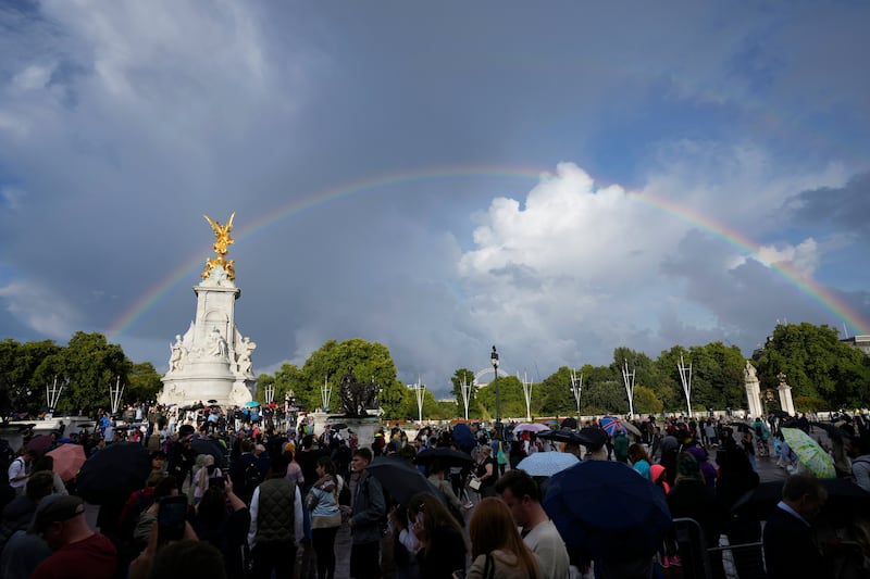 People gather outside Buckingham Palace in London as a double rainbow appears in the sky, Thursday, Sept.  8, 2022.  Buckingham Palace says Queen Elizabeth II has been placed under medical supervision because doctors are "concerned for Her Majesty's health. " Members of the royal family traveled to Scotland to be with the 96-year-old monarch.  (AP Photo / Frank Augstein)