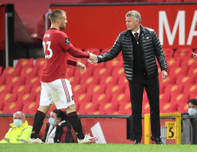 Manchester United's manager Ole Gunnar Solskjaer, right, shakes the hand of Luke Shaw as he leaves the pitch during the English Premier League soccer match between Manchester United and Southampton at Old Trafford in Manchester, England, Monday, July 13, 2020. (AP Photo/Peter Powell,Pool)