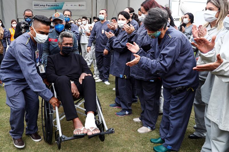 Nelio Di Moura Moyses, 55, leaves amid applause from the medical personnel of the Campaign Hospital of the Pacaembu stadium after his recovery from Covid-19, in Sao Paulo, Brazil.  EPA