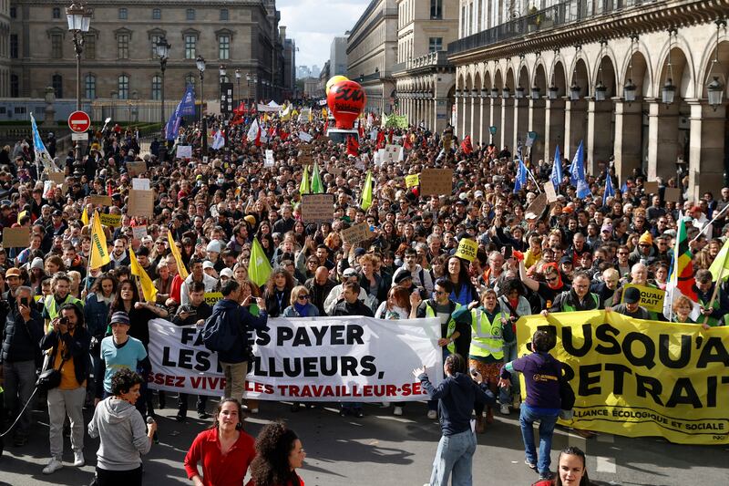 Protesters walk past the Louvre in Paris. Reuters