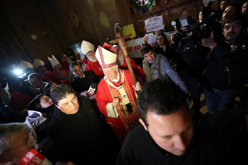 Archbishop of Santiago, Ricardo Ezzati attends his religious service as citizens protest against him after being summoned to testify in an investigation into the alleged cover-up of child sexual abuse by members of the Catholic Church, at the Santiago cathedral, in Santiago, Chile, July 25, 2018. Picture taken July 25, 2018. REUTERS/Ivan Alvarado