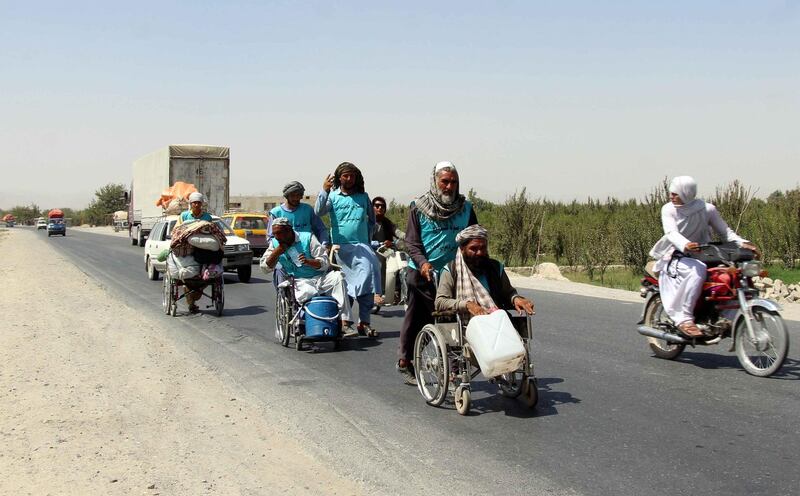 Afghan people, some in wheelchairs, reach Kandahar province on a journey by foot from Herat province to Kabul to cover a distance of about 1,800km, calling an end to decades old war, in Kandahar, Afghanistan. EPA