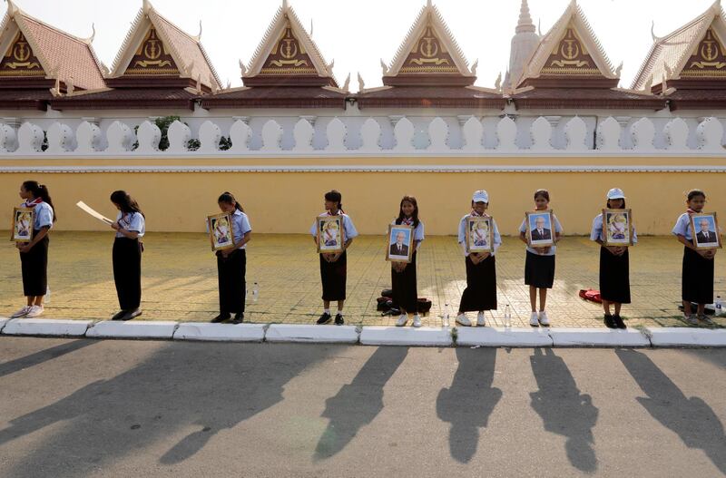 Cambodian students hold portraits of Vietnamese President Nguyen Phu Trong and Cambodian King Norodom Sihamoni during a welcoming ceremony at the Royal Palace in Phnom Penh. EPA
