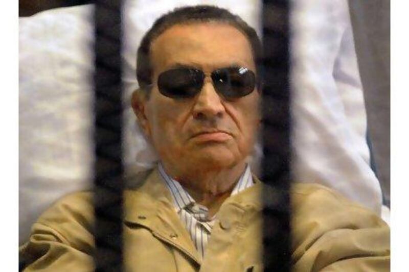 Ousted Egyptian president Hosni Mubarak sits inside a cage in a courtroom during his verdict hearing in Cairo Saturday.