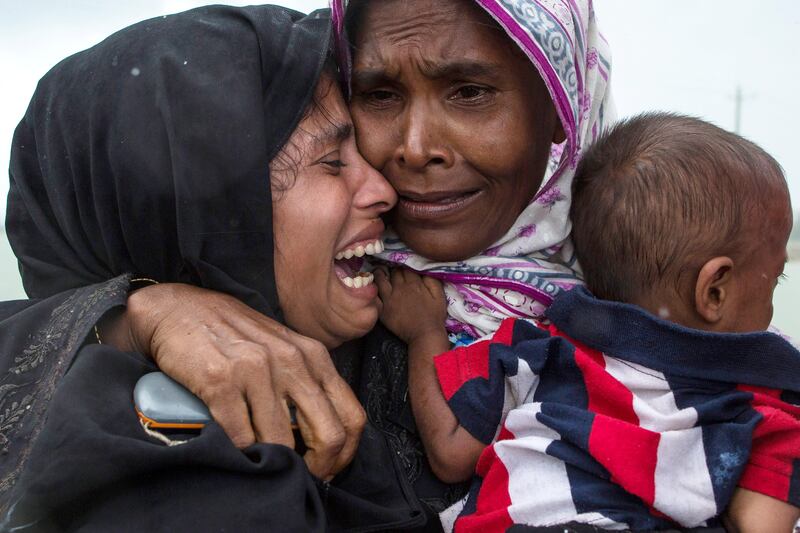 DAKHINPARA, BANGLADESH - SEPTEMBER 08:  Rohingya Muslim refugees react after being re-united with each other after arriving on a boat from Myanmar on September 08, 2017 in Whaikhyang Bangladesh. Thousands of Rohingya continue to cross the border after violence erupted in Myanmar's Rakhine state when the country's security forces allegedly launched an operation against the Rohingya Muslim community.  (Photo by Dan Kitwood/Getty Images) *** BESTPIX ***