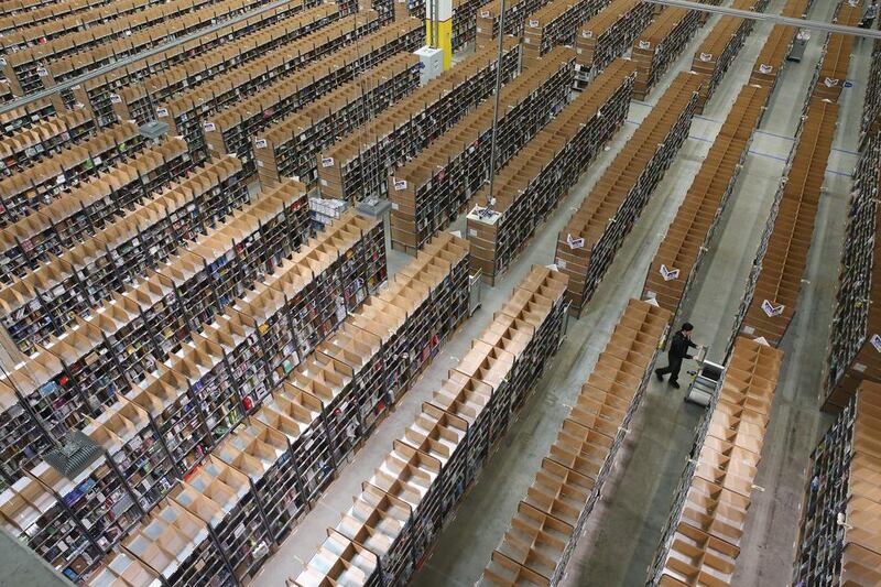 A worker pushes a cart among shelves lined with goods at an Amazon warehouse in Brieselang, Germany. In the United States, Amazon accounts for 65 per cent of all new book sales. Sean Gallup / Getty Images 