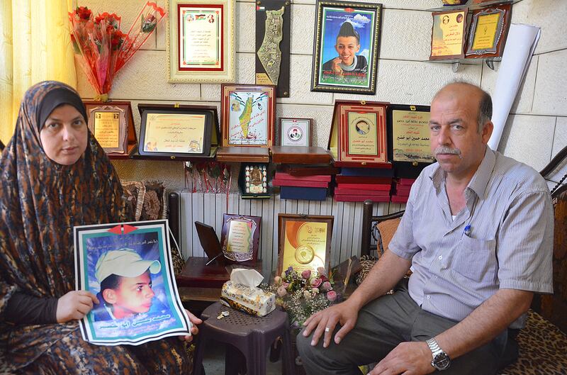 Suha Abu Khdeir and Hussein Khdeir hold a photo of their son Mohammed Abu Khdeir who was killed last year by Israeli vigilantes. Kate Shuttleworth for The National