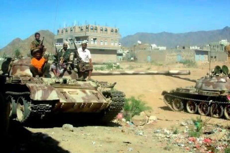 Tribal fighters, who back the Yemeni army, ride on a tank in Abyan province. Today, Ansar Al Sharia, Yemen's Al Qaeda offshoot, released 73 soldiers captured in running battles with government forces.