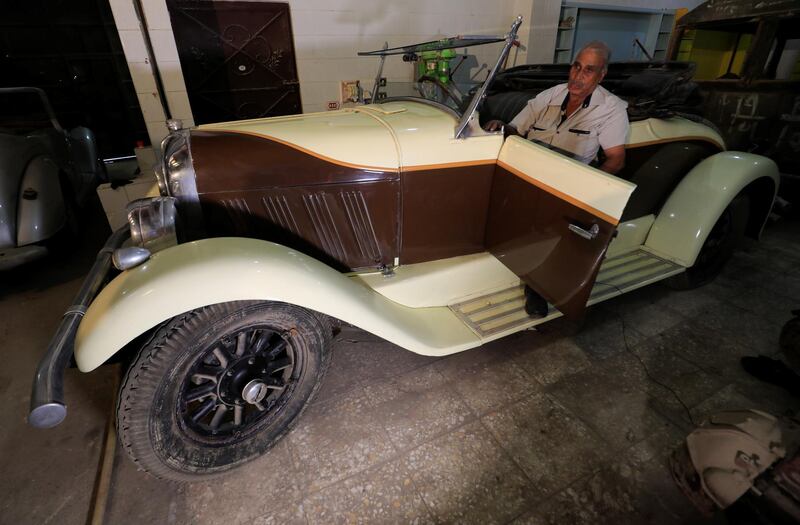 Sayed Sima speaks during an interview with Reuters seated on a 120-year-old American 1900 Auburn car in his store. Reuters