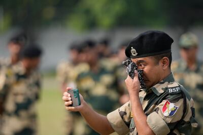 An Indian Border Security Force soldier takes a video of a wreath-laying ceremony for his colleague Lal Fam Kima in Jammu on Thursday. Lal Fam Kima was killed when Indian and Pakistani soldiers exchanged gunfire in disputed Kashmir.  AP