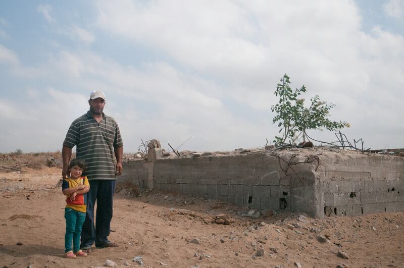 Abu Saad and his daughter stand in front of the remains of their home which has been destroyed three times by Israel. Creede Newton for The National