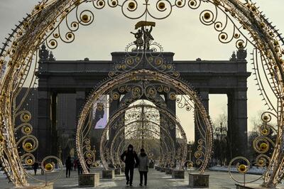 People wearing protective facemask walk past festive decorations set for Christmas and the upcoming New Year's celebrations, in Moscow on December 27, 2020, amid the ongoing Covid-19, (the novel coronavirus) pandemic. Russia confirmed 28,284 new Covid-19 cases on December 27. / AFP / Kirill KUDRYAVTSEV
