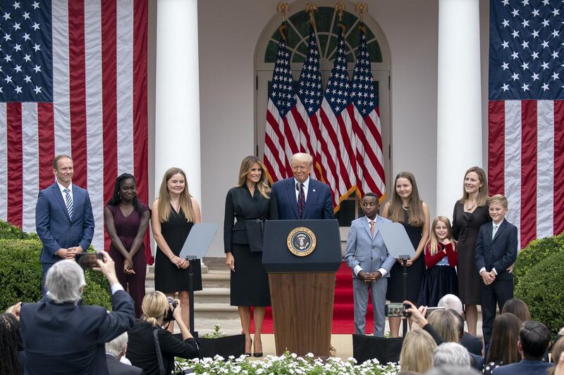 US President Donald Trump, First Lady Melania Trump, Supreme Court Justice nominee Amy Coney Barrett and her family stand on stage following a ceremony in the Rose Garden of the White House in Washington. Bloomberg