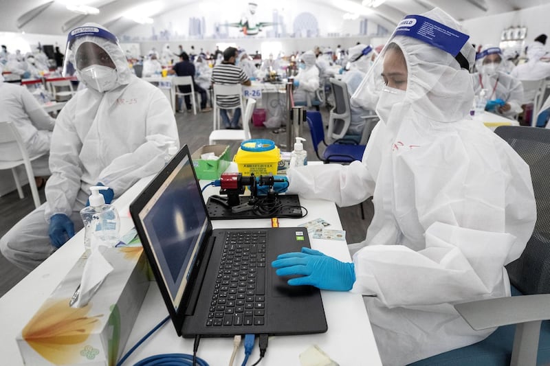 ABU DHABI, UNITED ARAB EMIRATES. 05 AUGUST 2020. The DPI Screening facility along the border between Dubai and Abu Dhabi which screens travellers for the COVID-19 virus using a blood sample and laser technology. It is a quick blood test and results are out in a matter of minutes. A nurse checkes the results of the blood test with the laser device on a laptop work station. (Photo: Antonie Robertson/The National) Journalist: Nick Webster. Section: National.