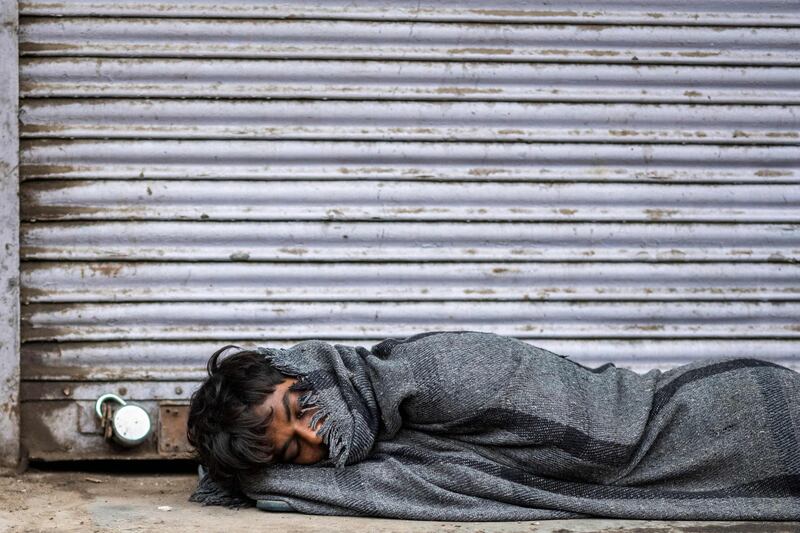 A man sleeps in front of a closed shop in New Delhi, India, during a government-imposed lockdown to combat the spread of the coronavirus. AFP