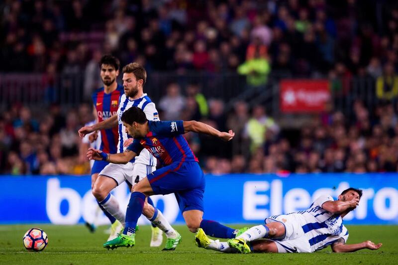 Luis Suarez, centre, of Barcelona fights for the ball with Asier Illarramendi, left, and Raul Navas of Real Sociedad. Alex Caparros / Getty Images