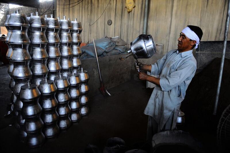 A labourer inspects a pot at an aluminium workshop in Herat.