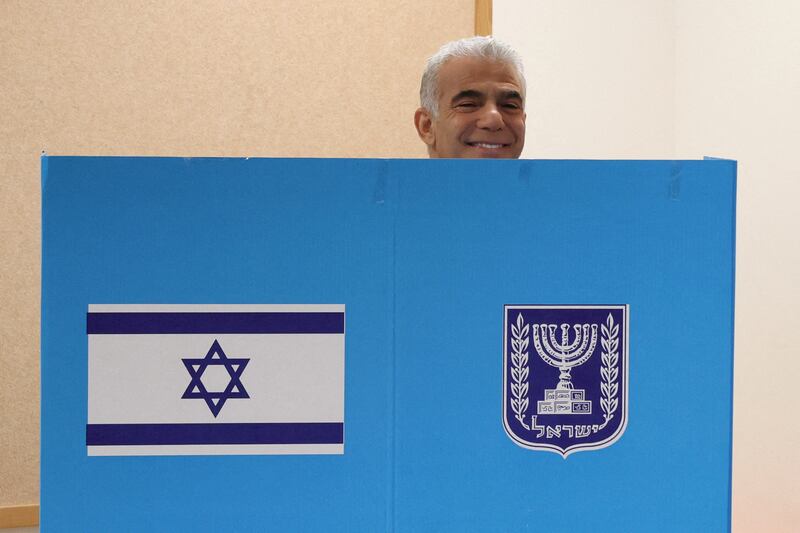 Israeli Prime Minister Yair Lapid smiles as he casts his vote at a polling station in Israel's coastal city of Tel Aviv. Mr Lapid urged the electorate to cast their ballot after voting in an election that might lead to veteran leader Benjamin Netanyahu making a comeback alongside far-right allies.  Reuters