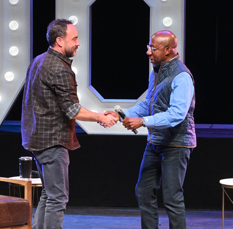 Musician Dave Matthews and Senator Raphael Warnock greet each other onstage during a special acoustic performance and rally at Coca-Cola Roxy in Atlanta. Getty Images