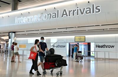 Passengers wearing PPE (personal protective equipment), including a face mask as a precautionary measure against COVID-19, walk through the arrivals hall after landing at at Terminal Two of London Heathrow Airport in west London, on May 9, 2020. - Britain could introduce a 14-day mandatory quarantine for international arrivals to stem the spread of coronavirus as part of its plan to ease the lockdown, an airline association said Saturday, sparking alarm in an industry already badly hit by the global pandemic. (Photo by JUSTIN TALLIS / AFP)