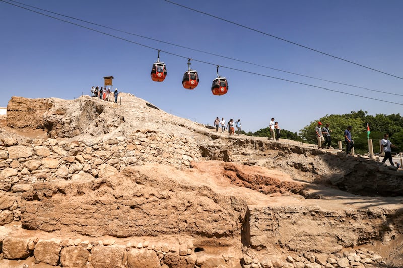 Cable cars pass tourists visiting the pre-historic site of Tell es-Sultan, near the occupied West Bank city of Jericho. All photos: AFP