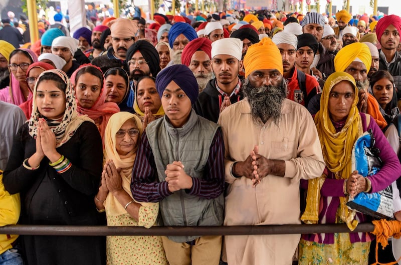Sikh devotees pay their respects on the occasion of the 550th birth anniversary of Guru Nanak Dev at Gurudwara Ber Sahib in Sultanpur Lodhi on November 12, 2019. Sporting saffron and blue turbans and headscarves, hundreds of thousands of devotees braved smog to pack the city of Sultanpur Lodhi in India for the 550th birth celebrations of Sikhism's founder Guru Nanak. AFP