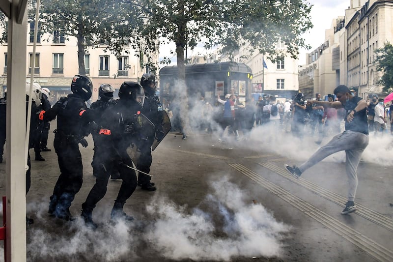 Demonstrators clash with police at the end of a national day of protest against French legislation making a Covid-19 health pass compulsory to visit a cafe, board a plane or travel on an inter-city train, in Paris.