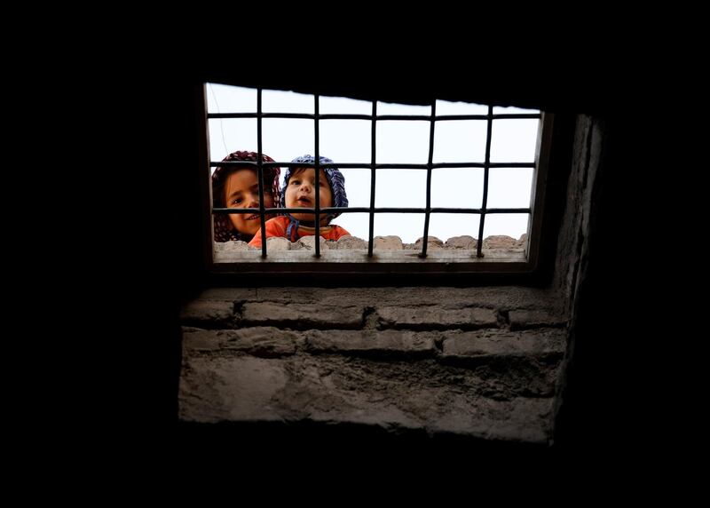 Children look through the window of a building in the old city of Herat in Afghanistan. Reuters