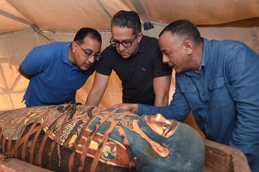 Egyptian Prime Minister Mustafa Madbouly, left, Egyptian Minister of Antiquities Khaled el-Anany and secretary-general of the Supreme Council of Antiquities Mostafa Waziri inspect one of the coffins discovered at an ancient burial shaft at a necropolis in Saqqara, south of Cairo. EPA