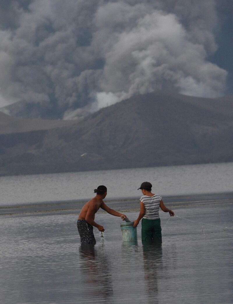 Residents living along Taal lake catch fish as Taal volcano erupts in Tanauan town, Batangas province south of Manila. AFP