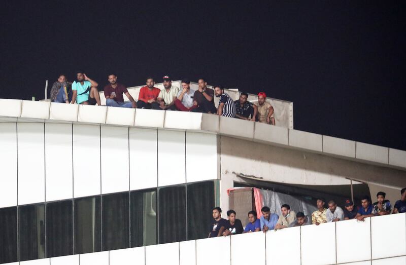 Fans watching the match from the roof of a nearby building.
