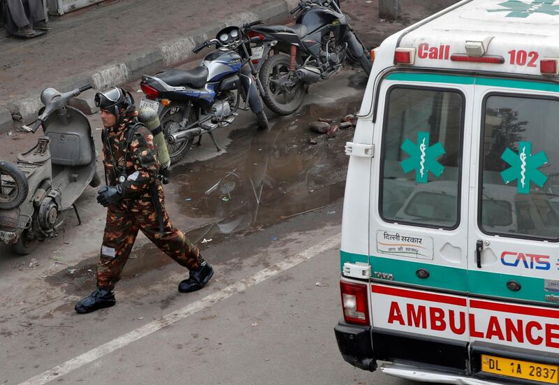 A member of India's National Disaster Response Force (NDRF) walks after searching for survivors at the site of a fire that swept through a factory where laborers were sleeping, in New Delhi, India.  Reuters