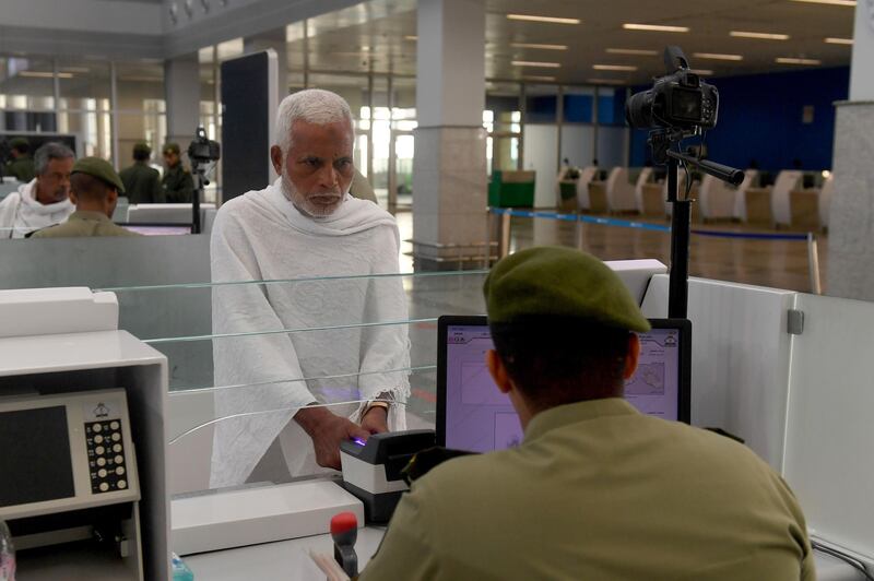 Pilgrims go through passport control. AFP