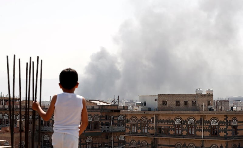 A Yemeni boy looks at smoke billowing above a neighborhood following Saudi-led airstrikes targeting positions in Sana'a, Yemen. EPA