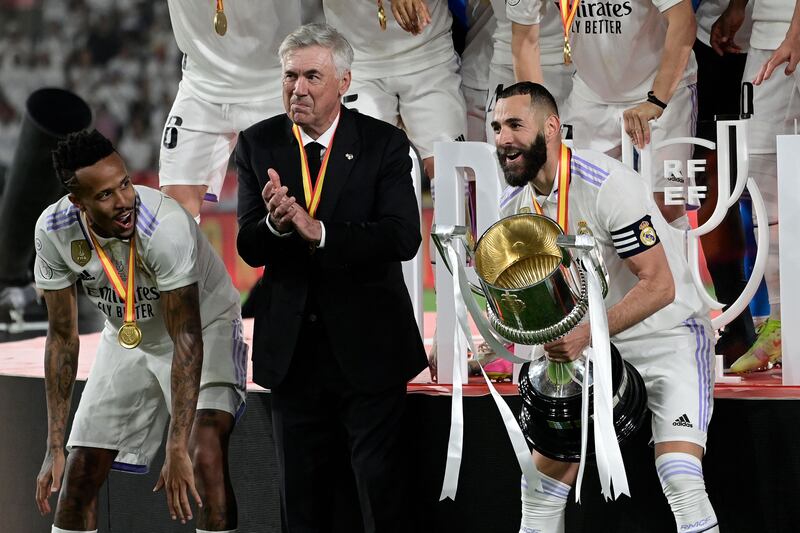 Eder Militao, Carlo Ancelotti and Karim Benzema celebrate with the Copa del Reey trophy. AFP