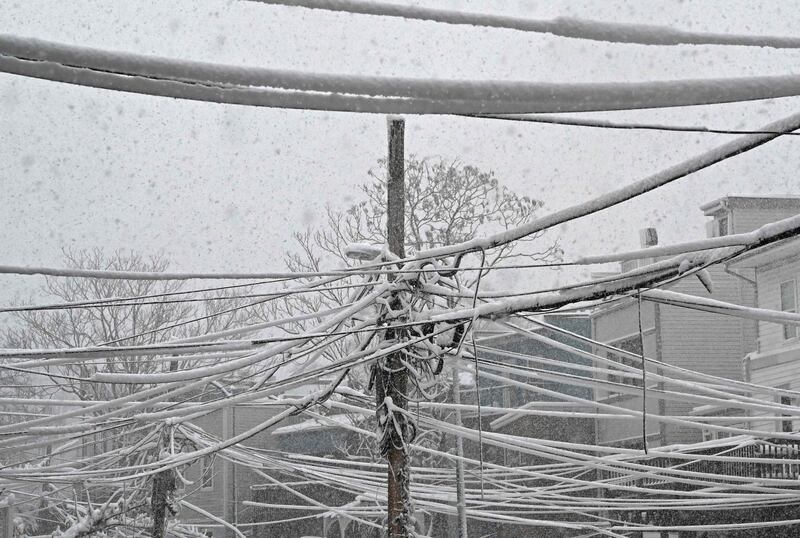 Snow-covered cable and power lines crisscross a backyard alley in a neighbourhood in Washington.  AFP