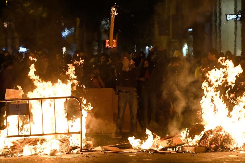 Catalan protesters gesture behind barricades in flames after a demonstration called by the local Republic Defence Committees (CDR) in Barcelona on October 17, 2019. AFP / LUIS GENE