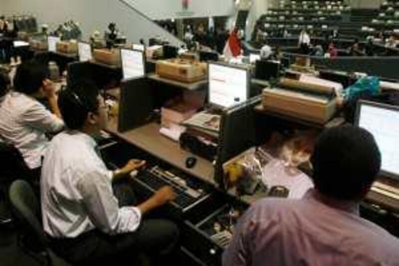 Indonesian brokers monitor share prices at the Jakarta Stock Exchange July 14, 2009. President Susilo Bambang Yudhoyono, re-elected in a landslide last week, said last Thursday he would give priority to spurring economic growth amid a global slowdown.  REUTERS/Crack Palinggi  (INDONESIA BUSINESS)
