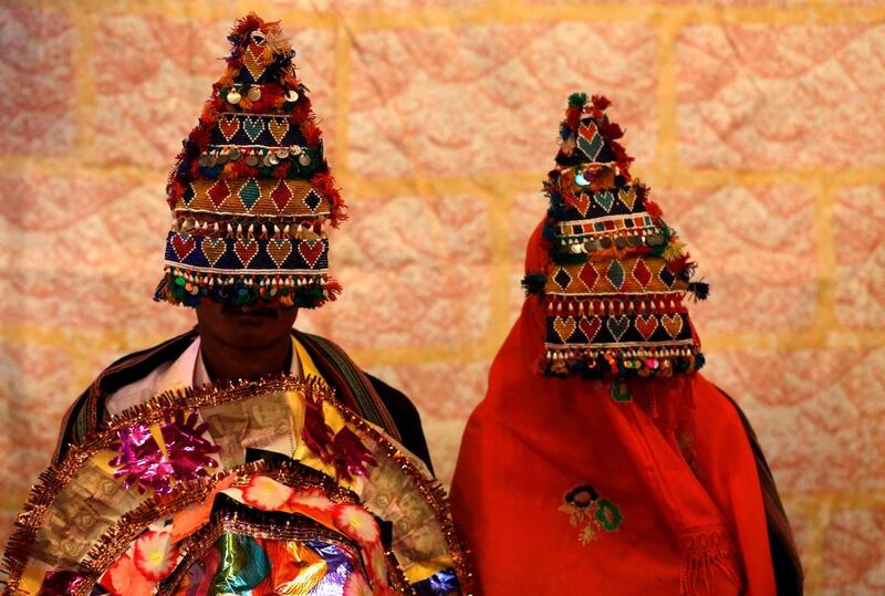 A bride and groom wearing traditional handmade garlands wait for their wedding to start during a mass marriage ceremony in Karachi, Pakistan. Akhtar Soomro / Reuters