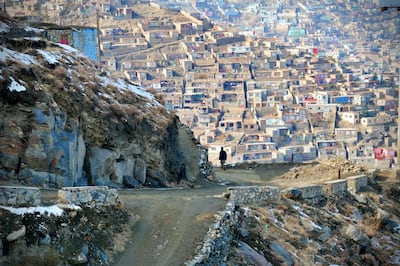 Pictured: A man walks down Asamayi mountain with a view of Kabul's pastel-coloured houses and snow-capped verges. 
Photo by Charlie Faulkner
November 2020