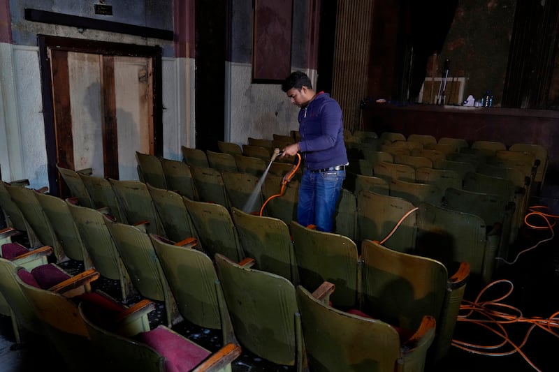 Bangladeshi volunteer and actor Shuman Dali, 39, washes chairs before attending a rehearsal for a play at the cinema.