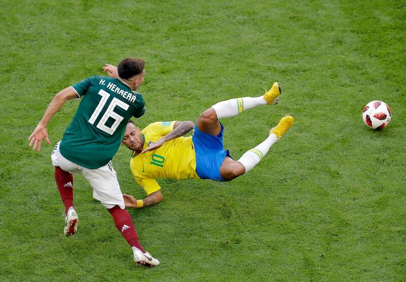 Neymar is tackled by Mexico's Hector Herrera. Sergei Grits / AP Photo