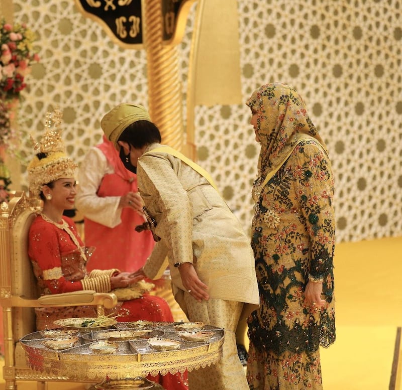 Princess Fadzilah is greeted by Queen Saleha during the berbedak mandi ceremony.