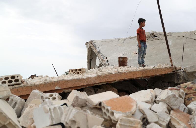 A Syrian boy stands above the rubble of a building in the village of Rabaa Jour in the the extremist-held Syrian province of Idlib following reported shelling and air strikes in the area. AFP
