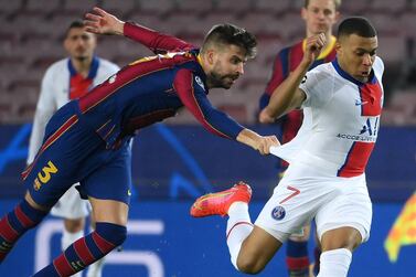 Barcelona defender Gerard Pique desperately tries to hold on to PSG's hat-trick hero Kylian Mbappe. AFP