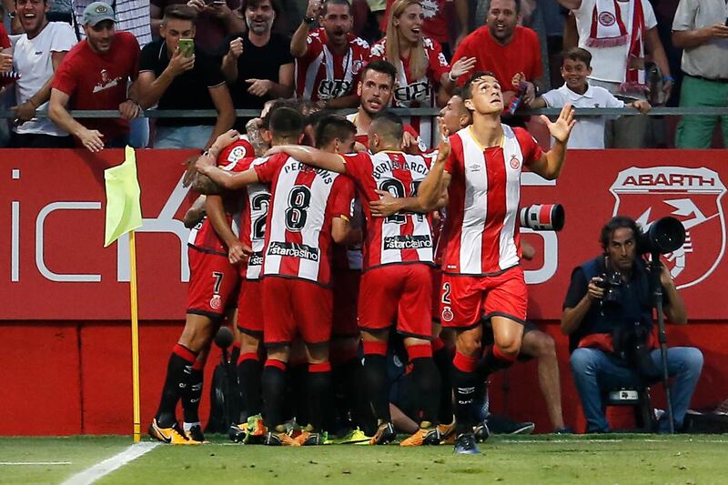 Girona's Uruguayan Cristhian Stuani celebrates with teammates after scoring during the Spanish league footbal match Girona FC vs Club Atletico de Madrid at the Montilivi stadium in Girona on August 19, 2017. / AFP PHOTO / PAU BARRENA