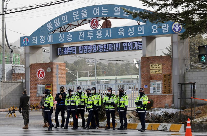 Police officers and soldiers stand guard outside an army boot camp near the demilitarised zone before the arrival of BTS member Jin in Yeoncheon, South Korea, on December 13. Reuters