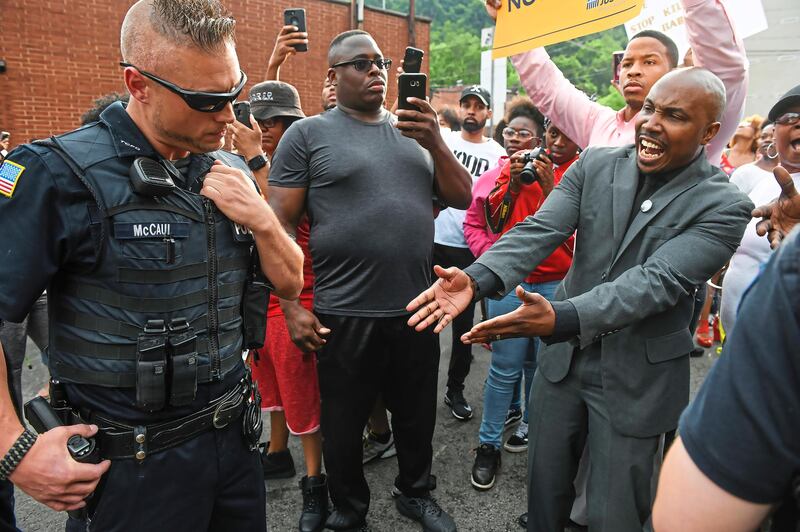 Leonard Hammonds, right, points out that a Turtle Creek Police officer has his had on his weapon during a rally in East Pittsburgh at a protest regarding the shooting death of Antwon Rose by an East Pittsburgh Police officer during a traffic stop the night before. Steve Mellon / Pittsburgh Post-Gazette via AP