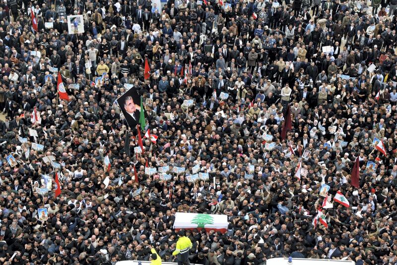 The national flag-draped coffin of Lebanon's slain former prime minister Rafiq Hariri is carried to his final resting place in central Beirut 16 February 2005. Hariri, who was killed in a massive explosion in the Lebanese capital two days ago, was buried after his coffin was caught in a crush of frenzied mourners outside a Beirut mosque. AFP PHOTO/JOSEPH BARRAK (Photo by JOSEPH BARRAK / AFP)