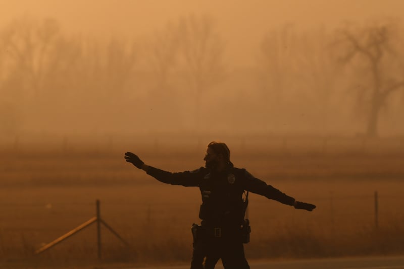 A police officer directs operations amid palls of smoke in Louisville, Colorado.  AP
